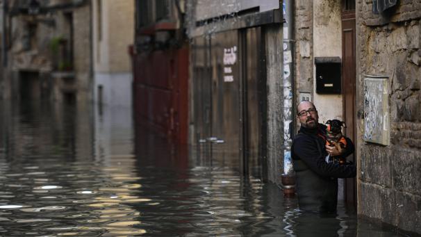 Un homme porte son chien, après les inondations qui ont eu lieu dans le nord de l’Espagne.