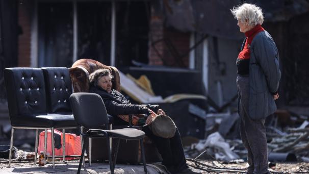 Des femmes discutent devant un bâtiment détruit par les bombardements dans la ville de Marioupol, en Ukraine.