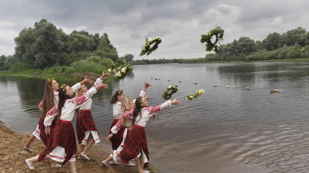 Des femmes biélorusses en costumes nationaux jettent des couronnes dans l