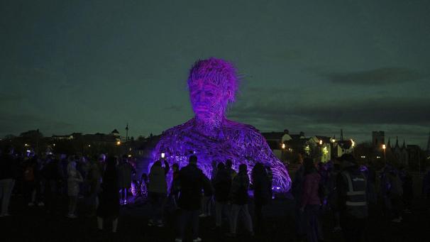 La foule observe le Con Mor, le Géant, de sept mètres de haut, exposé au Macnas Halloween show, à Galway, en Irlande.