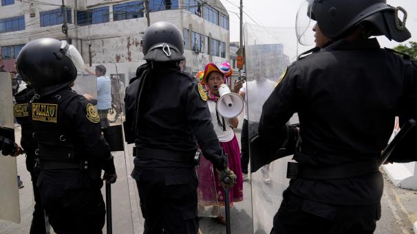 Une manifestante anti-gouvernemental défie la police entourant l