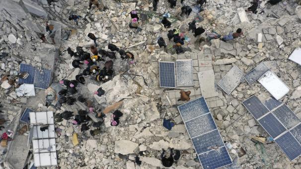 Des employés de la protection civile et des habitants fouillent les décombres de bâtiments effondrés dans la ville de Harem, près de la frontière turque, province d