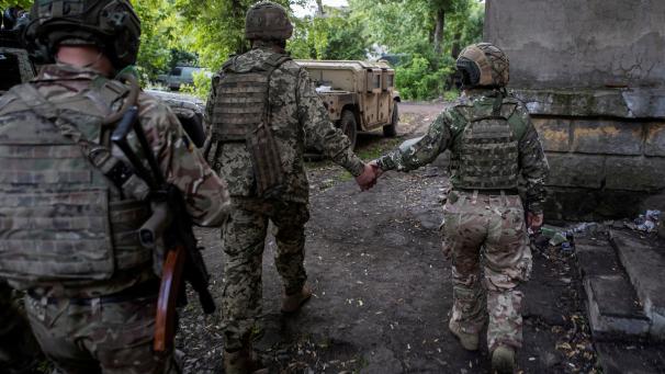 Des militaires ukrainiens se dirigent vers un véhicule blindé de transport de troupes à l’extérieur de la ville de Bakhmut, sur la ligne de front, au milieu de l’attaque russe contre l’Ukraine, dans la région de Donetsk, en Ukraine, le 23 mai 2023.