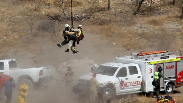 Des experts légistes travaillent avec plusieurs sacs de restes humains extraits du fond d’un ravin par un hélicoptère, qui ont été abandonnés dans la communauté de Mirador Escondido à Zapopan, dans l’État de Jalisco, au Mexique, le 31 mai 2023.