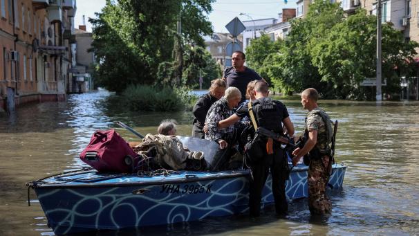 La police évacue des résidents des zones inondées après la destruction du barrage de Kakhovka.