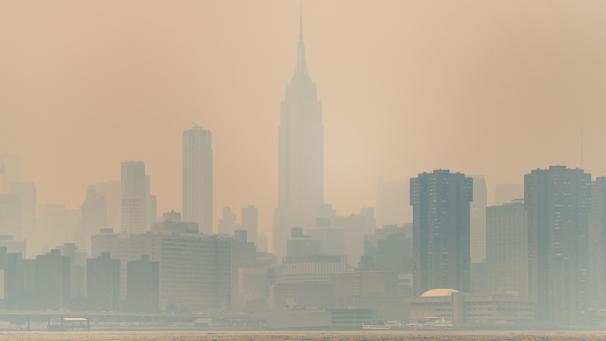 Vue de l’horizon de Manhattan avec l’Empire State Building au centre, depuis le parc Domino à Brooklyn, alors que la fumée des incendies de forêt canadiens détériore la qualité de l’air.