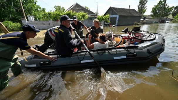 Des sauveteurs du service d’urgence ukrainien évacuent des habitants du village inondé d’Afanasiivka, le 9 juin 2023, après que le niveau d’eau de la rivière Ingulets a augmenté à la suite des dommages subis par le barrage de la centrale hydroélectrique de Kakhovka à Chornobaivka, dans la région de Kherson.