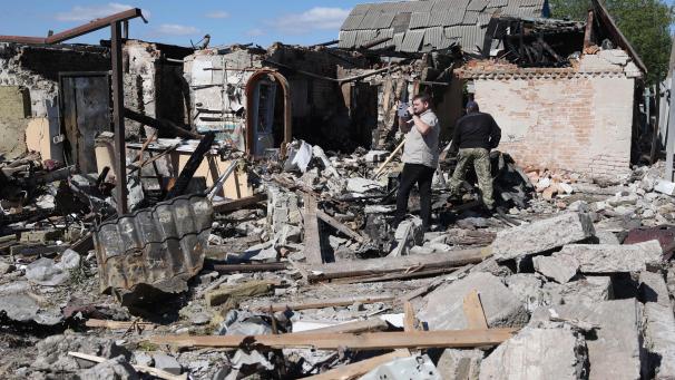 Des habitants examinent une maison privée détruite par une attaque de missiles dans le village de Krasylivka, dans la région de Kiev, le 8 mai 2024.