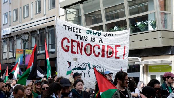 Des images montrent des banderoles avec des textes tels que « Bienvenue au festival de la chanson du génocide » et « Non au génocide ».