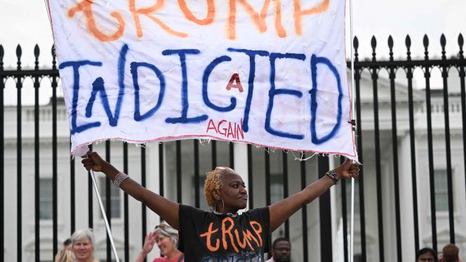 Une femme célébrant l’inculpation de Donald Trump devant la Maison-Blanche ce vendredi.