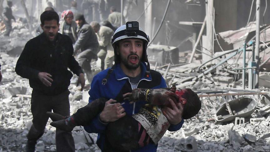 Un membre de la défense civile secourt un enfant blessé 
à Hammouriyé, une ville de la Ghouta sous le feu du régime.
