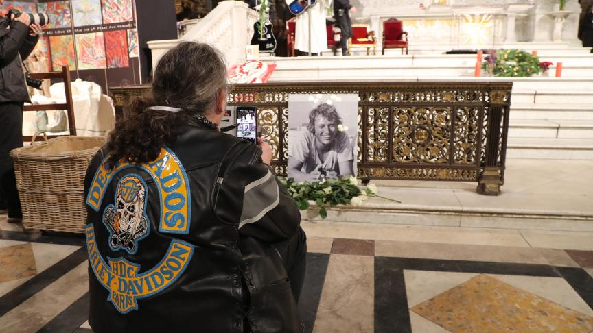 Un homme prend en photo le portrait de Johnny Hallyday, placé au coeur de la Madeleine.