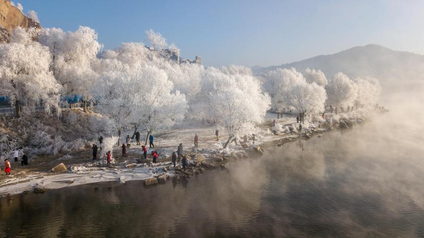 Le long de la Songhuajiang River dans le nord de la province Jilin en Chine, les habitants profitent de la beauté des paysages gelés, sous un ciel bleu sans nuage.