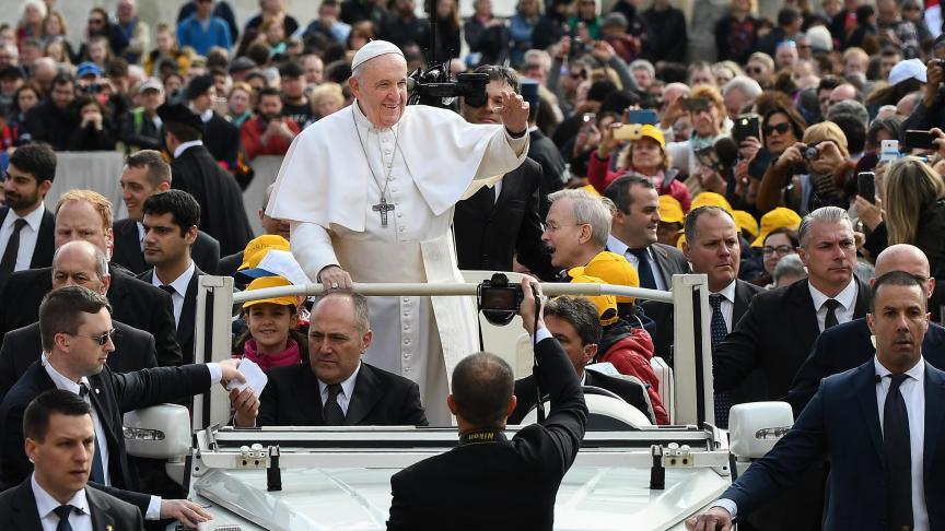 Le pape François fait signe aux adorateurs à son arrivée à l’audience générale hebdomadaire du 20 mars sur la place Saint-Pierre au Vatican.