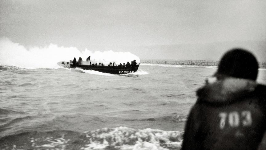 Le 6 juin 1944, une barge de débarquement s'approche  de Omaha Beach, couverte d'une épaisse fumée blanche.