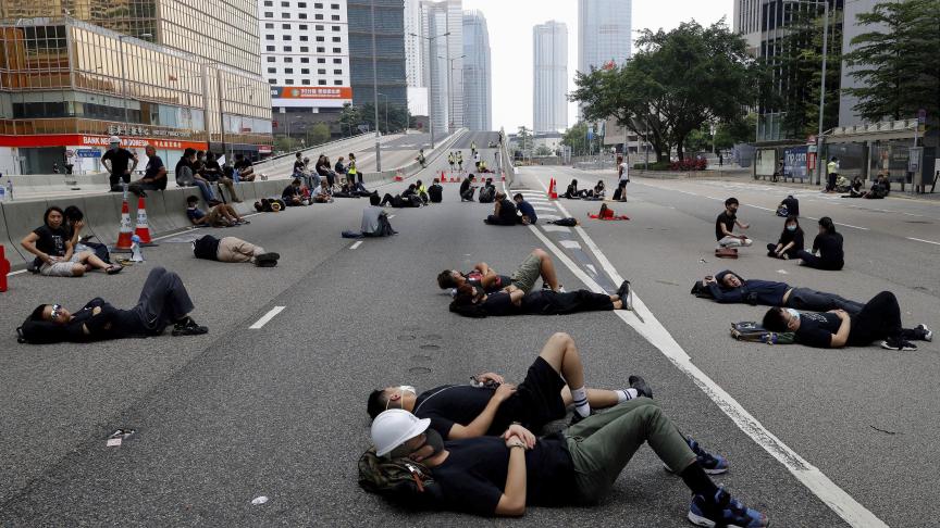 Les manifestants qui ont campé pendant la nuit se reposent le long d’une route principale près du Conseil législatif, après avoir continué à protester contre le projet de loi d’extradition impopulaire à Hong Kong.