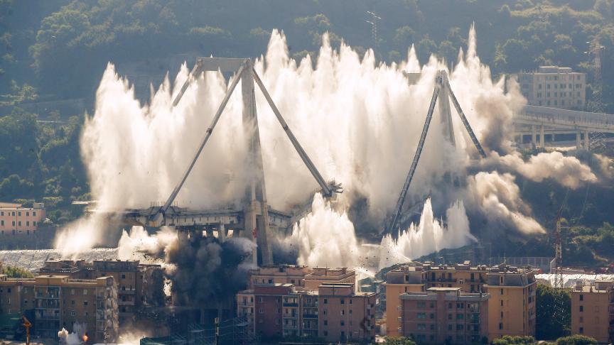 Un nuage de poussière s’élève alors que les travées restantes du pont Morandi ont été démolies dans une explosion planifiée à Gênes en Italie, ce vendredi 28 juin. Le pont italien s’est effondré l’année dernière, tuant 43 personnes.