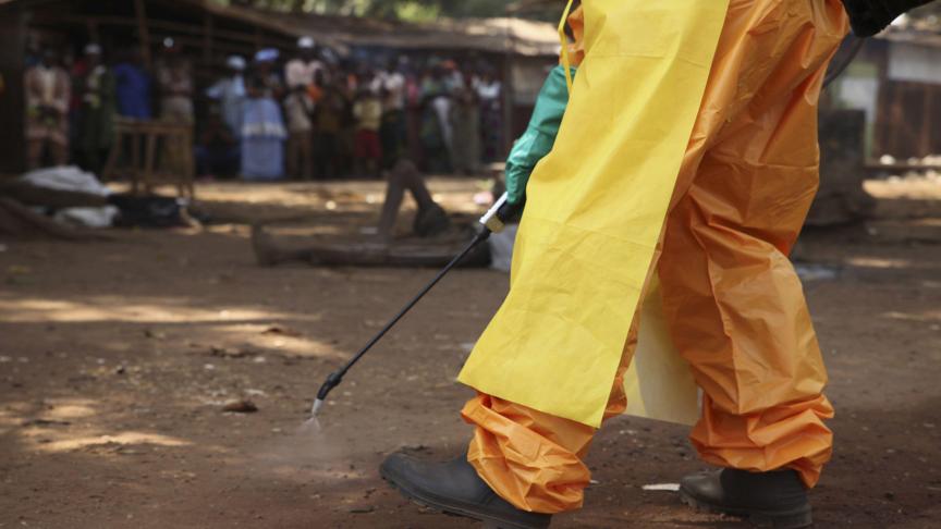 2015
: un membre de la Croix-Rouge française désinfecte la zone autour d’un potentiel porteur du virus Ebola à Forécariah, en Guinée.
