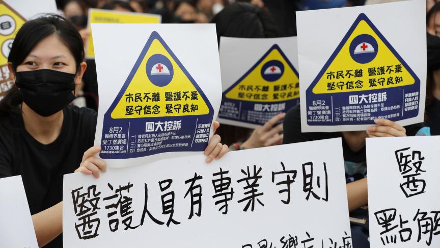 Des travailleurs du secteur médical et des soins de santé manifestent à Hong Kong pour éviter que les opinions politiques affectent les soins aux patients.
