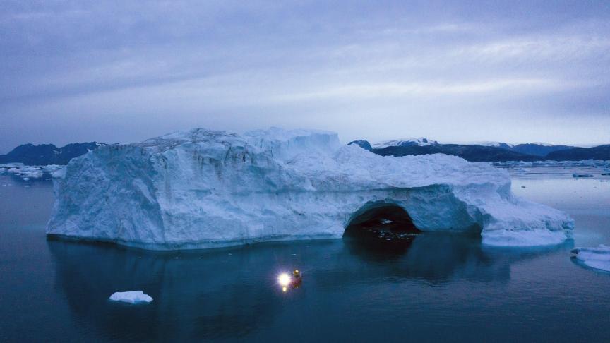 Un bateau navigue de nuit à côté d’un gros iceberg dans l’est du Groenland. Le Groenland a fondu plus rapidement au cours de la dernière décennie et, cet été, il a connu deux des plus fortes fontes jamais enregistrées depuis 2012.