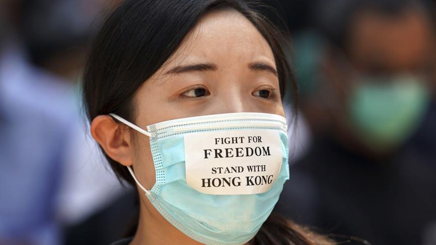 Une manifestante porte, sur son masque anti-pollution, un slogan en faveur de la liberté d’Hong-Kong.