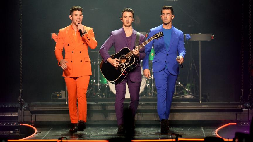 Les Jonas Brothers en concert. Et Nick Jonas dans son costume orange...