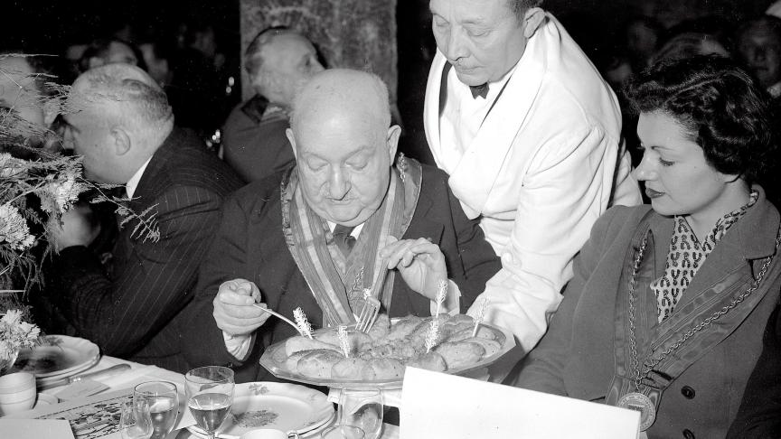 Le gastronome Curnonsky et la Comtesse de Bragard, au chapître de l'ordre du Tastevin tenu à Morey-Saint-Denis, à l'occasion de la Saint-Vincent. 26-1-1952.