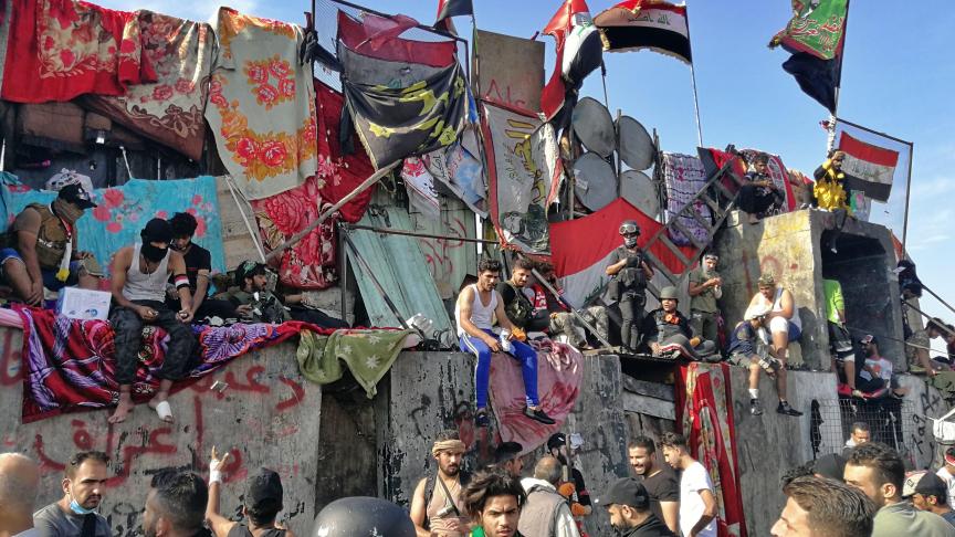Des manifestants anti-gouvernementaux occupent les barrières érigées par les forces de sécurité pour fermer un pont menant aux zones gouvernementales pendant les manifestations en cours à Bagdad, en Irak.