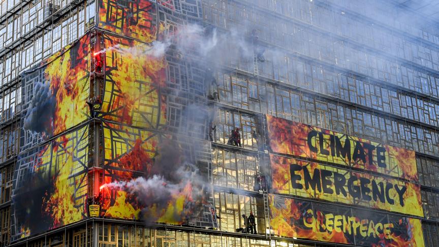 Plus de 60 militants de Greenpeace ont grimpé sur la façade du bâtiment Europa, qui accueille le Conseil européen, pour y déployer des bannières géantes. Le but: montrer que «notre maison est en feu. Il est maintenant temps pour une politique climatique décisive».