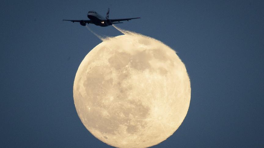Un avion vole et passe devant la lune à Londres. Donnant une photo poétique
!