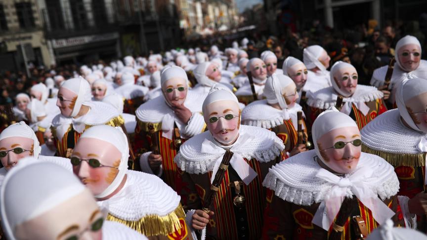 Un groupe de personnes déguisées en Gilles de Binche arrive à la Grand Place pour récupérer les médailles du jubilé à la Mairie lors du carnaval traditionnel de Binche.