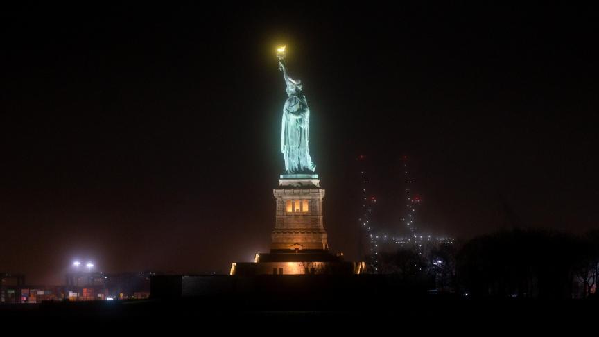 La statue de la Liberté brille dans la brume nocturne pendant la crise Covid-19 aux États-Unis.