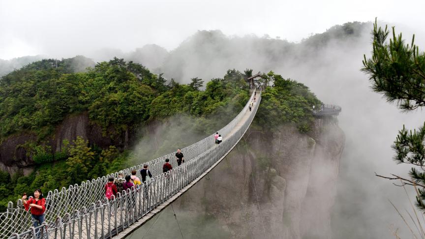 Vue aérienne de personnes marchant sur le pont Nantianmen, enveloppé de brouillard, dans la ville de Taizhou, à l’est de la Chine.