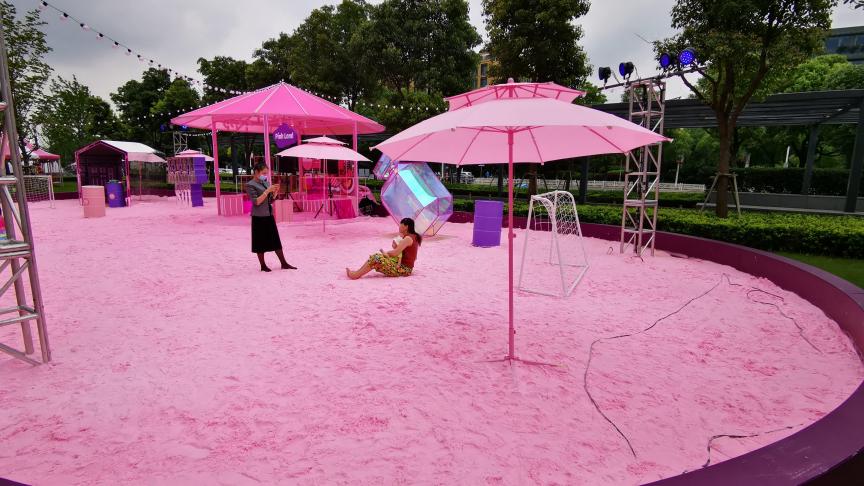 Des clients jouent dans une aire de jeux rose, composée de sable rose et d’installations roses, érigée par un centre commercial de Shanghai en Chine.