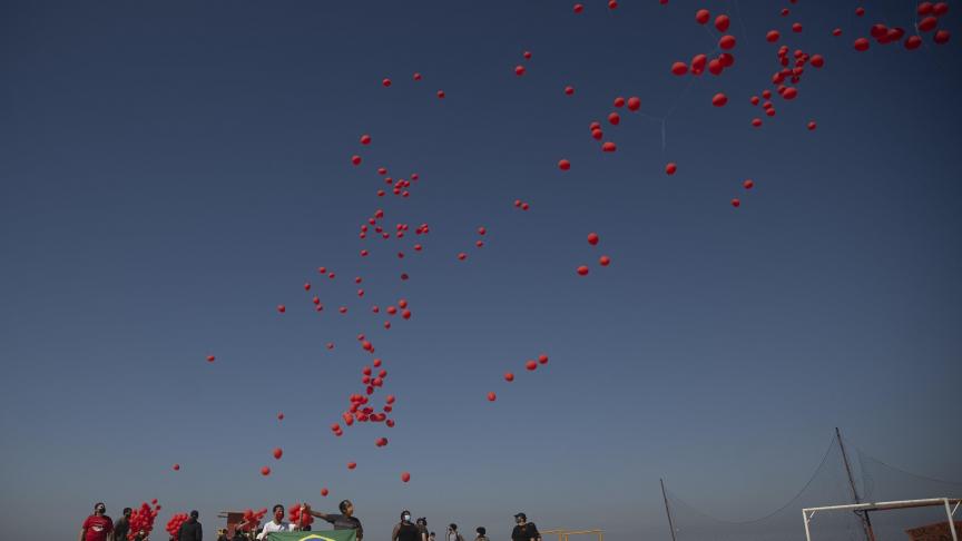 Des ballons rouges sont libérés pour rendre hommage aux victimes du coronavirus sur la plage de Copacabana à Rio de Janeiro, au Brésil.