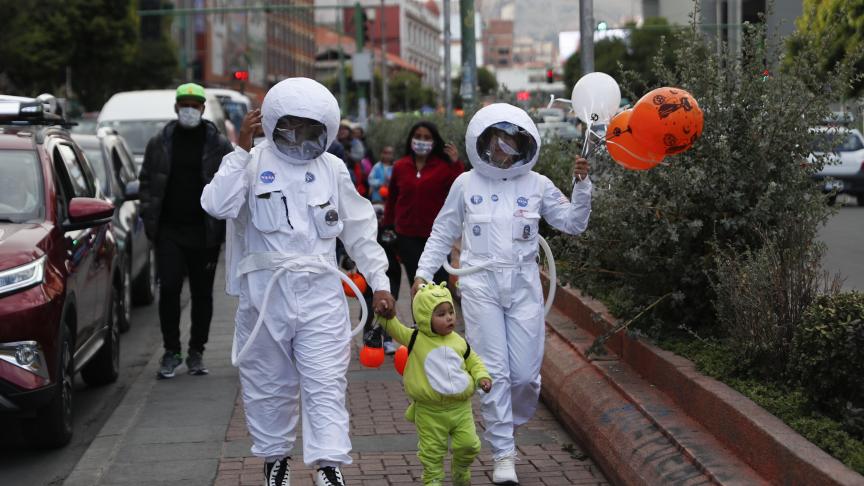 Des personnes portant des costumes d’astronaute de la NASA et un enfant déguisé en extraterrestre durant la fête d’Halloween à La Paz, en Bolivie.