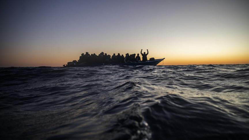 Des migrants et réfugiés de différentes nationalités africaines attendent une assistance sur un bateau en caoutchouc surpeuplé au large des côtes libyennes.