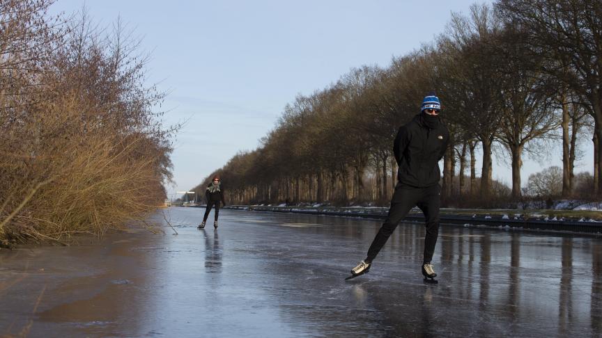 Deux patineurs profitent des joies de la glisse sur un canal gelé près de Nieuweschoot, dans le nord des Pays-Bas.