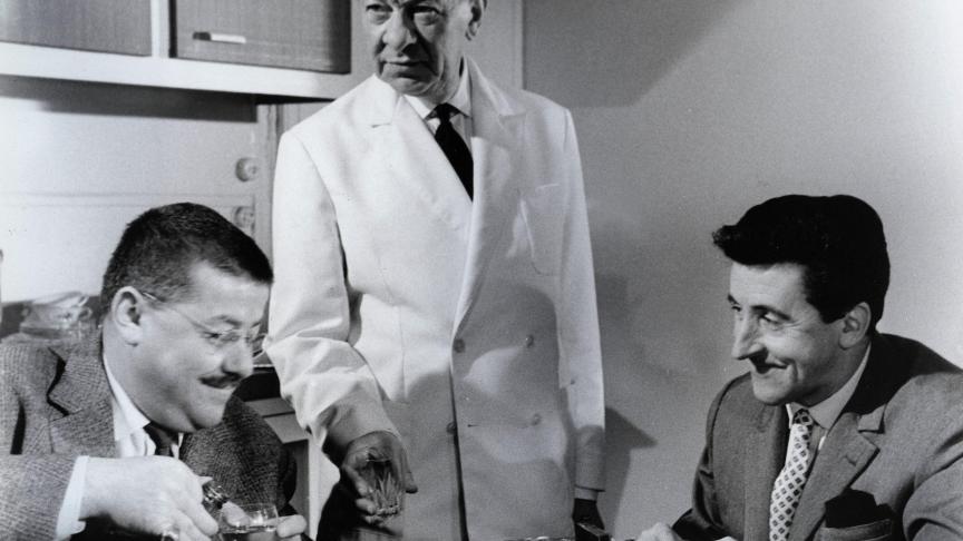 Dans « Les Tontons Flingueurs », Francis Blanche (à gauche) sert une goutte de « Trois étoiles » à Jean Lefebvre. Ce dernier ne sait pas qu’il y a vraiment de l’alcool dans son verre !