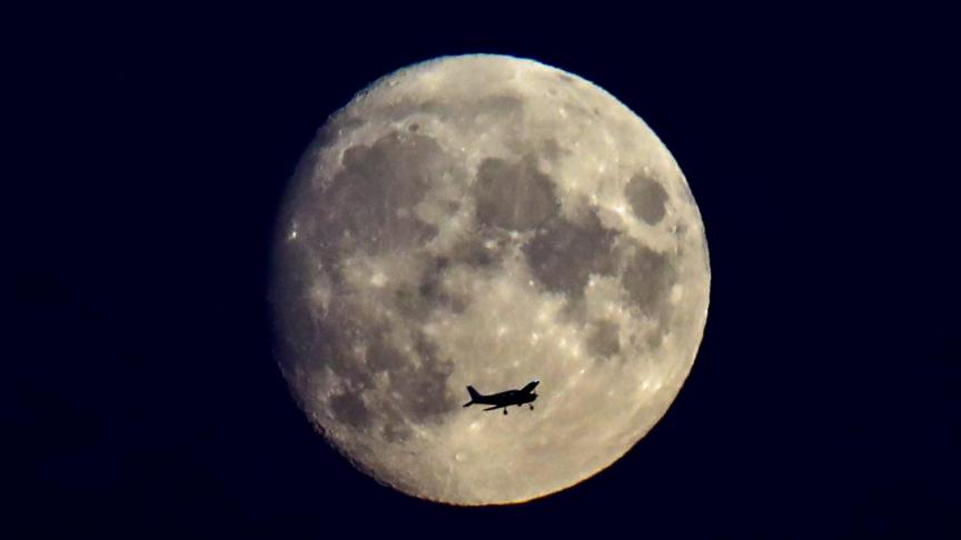 Un avion volant devant la pleine lune à Novossibirsk, en Russie.