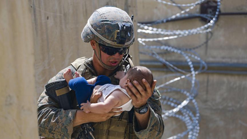 Un marine des États-Unis réconforte un nourrisson pendant une évacuation à l’aéroport international de Kaboul, en Afghanistan.