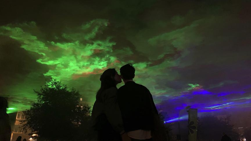 Un couple s’embrasse avec derrière eux, l’installation de l’artiste Dan Acher à Anvers.