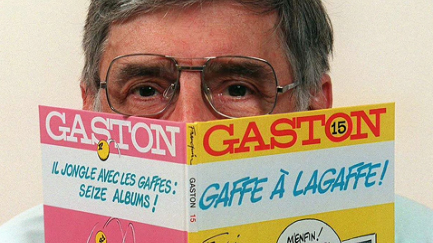André Franquin, caché derrière le dernier album de Gaston. Il a dessiné les aventures de ce drôle de personnage jusqu’en 1996.
