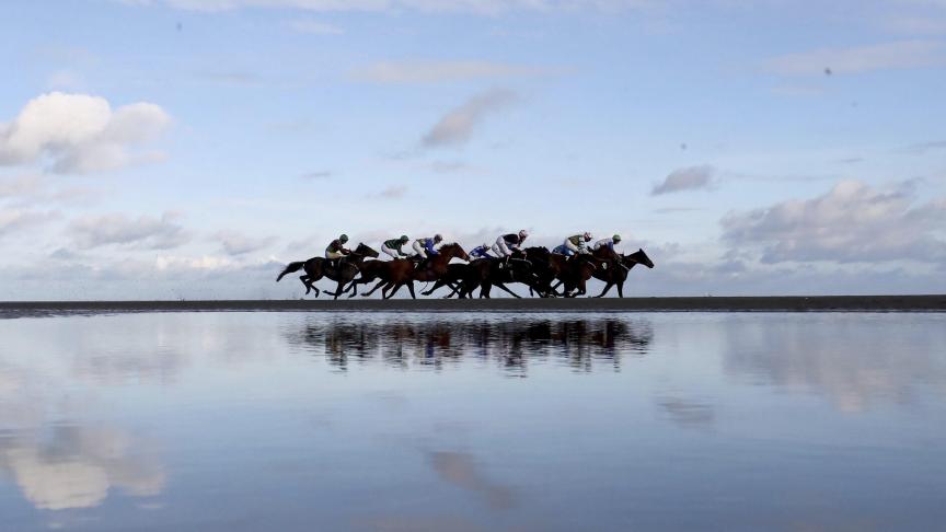 Des cavaliers font la course pour le Melbourne 10, à Laytown en Irlande.