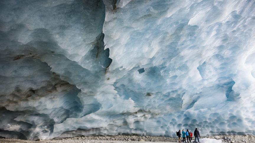 Des randonneurs visitent une grotte formée dans le glacier de Zinal en Suisse.
