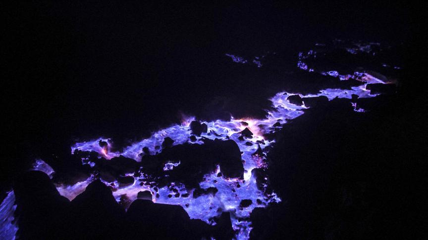 Le gaz de combustion réagit au contact avec l’oxygène et allume des lumières bleues de dans le cratère du volcan Ijen à Java, en Indonésie.