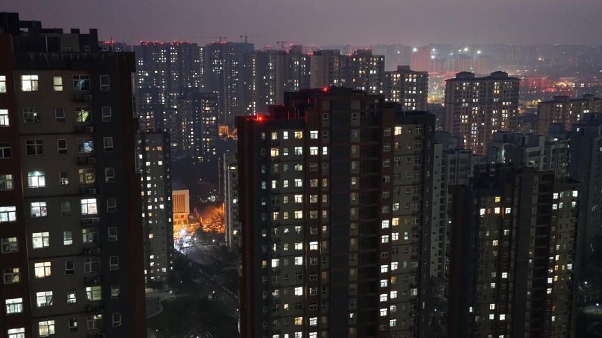 Les bâtiments résidentiels d'une communauté fermée sont illuminés la nuit pour accueillir le Nouvel An 2022 à Xi'an, dans la province de Shaanxi, en Chine.