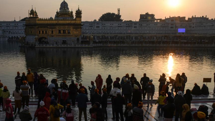 Des fidèles sikhs présentent leurs respects lors du dernier coucher de soleil de 2021, au sanctuaire sikh Golden Temple à Amritsar en Inde.