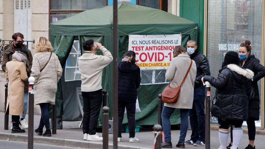 Des membres du public font la queue devant une pharmacie pour recevoir des tests antigéniques covid-19 à Paris le 6 janvier 2022.