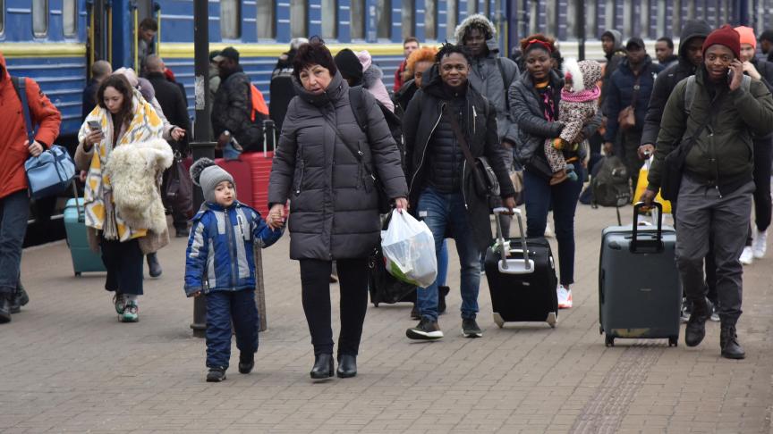 Des passagers venant de villes de Sumy et de Kiev, marchent sur le quai d'une gare à leur arrivée à Lviv, en Ukraine, le 25 février.
